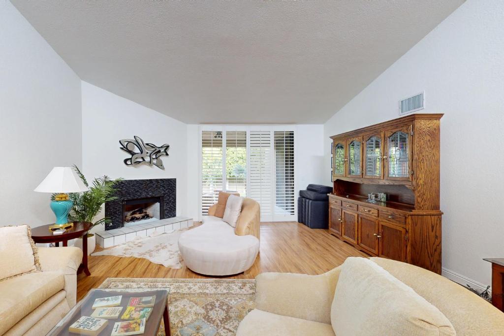 a living room with a couch and a fireplace at Palm Oasis Escape in Palm Springs