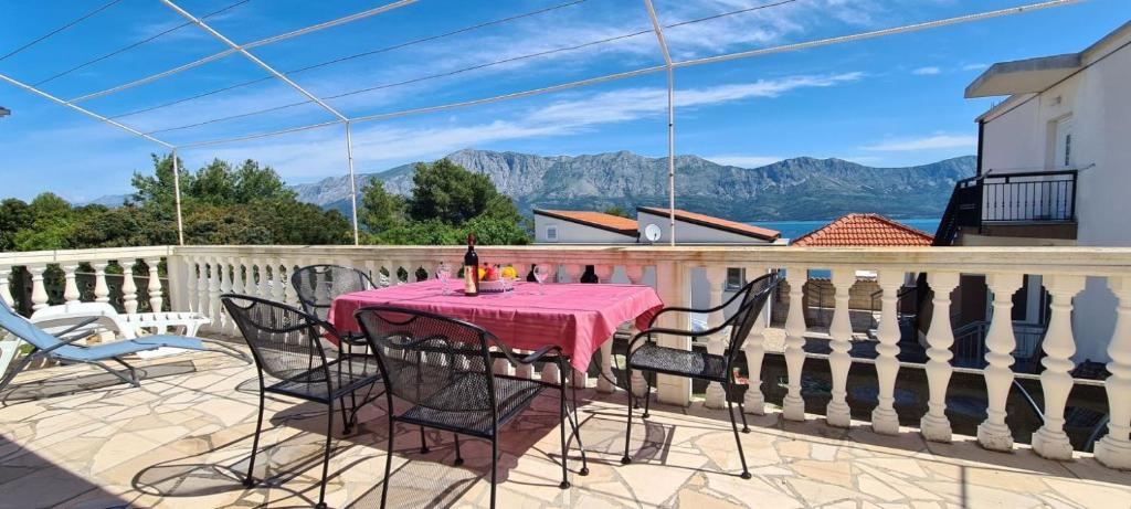 a table on a balcony with a view of the mountains at House Karmela in Sućuraj