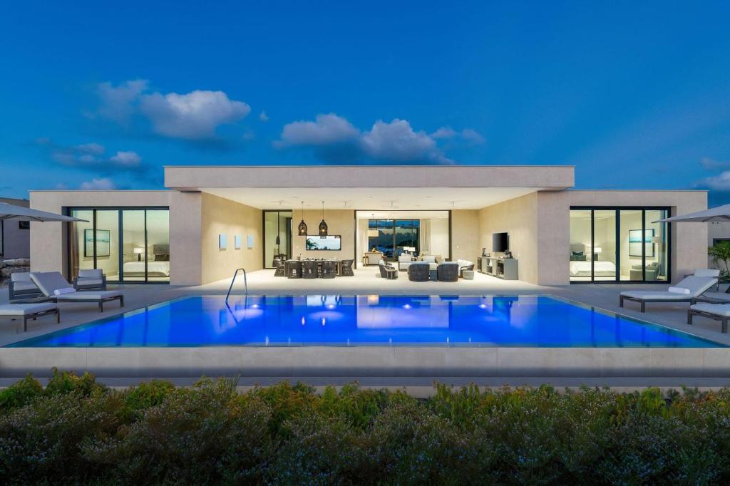 a house with a large swimming pool in front of it at Apes Hill Barbados Golf and Resort Community in Saint James