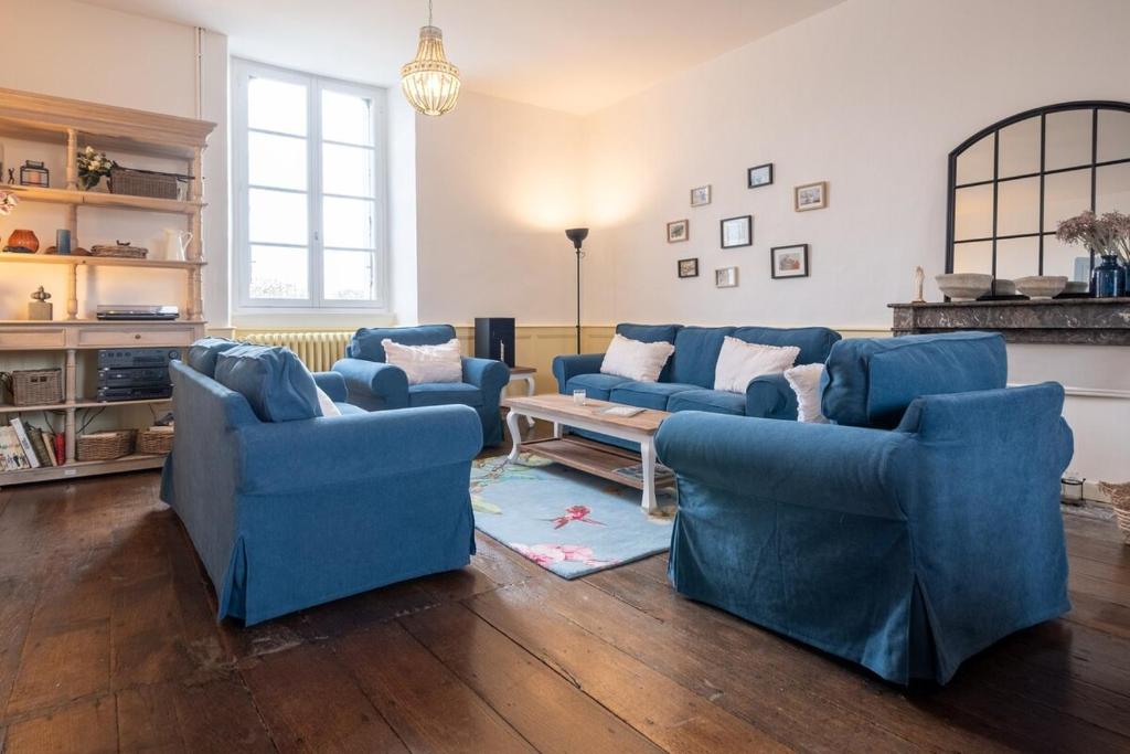 a living room with blue couches and a table at Charming house Le Clos Marie in Châteaubourg
