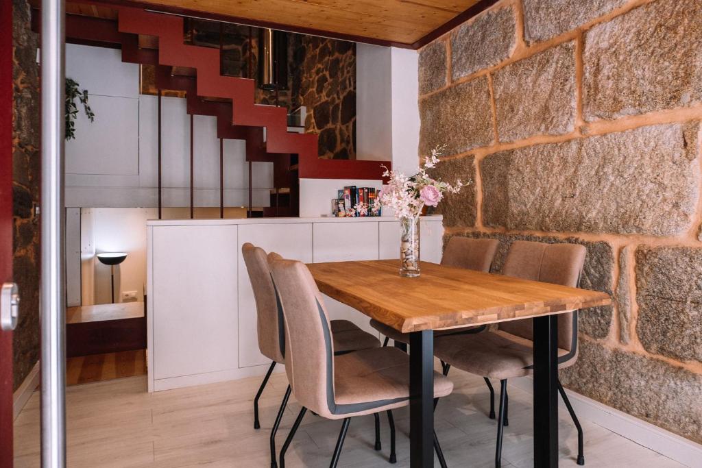 a kitchen and dining room with a wooden table and chairs at A 5 min de las Playas de Cangas by CABANA Rentals in Cangas de Morrazo