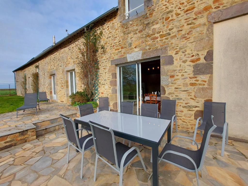 - une table et des chaises sur une terrasse en pierre dans l'établissement Le gîte du Cormier, à Saint-Aubin-du-Désert