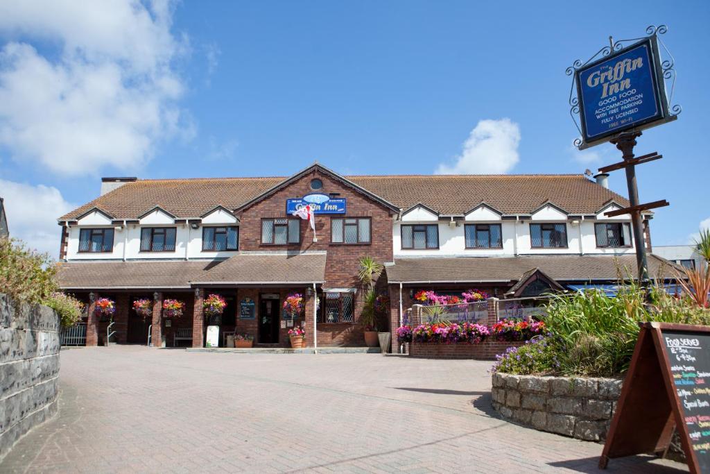 un grand bâtiment avec un panneau devant lui dans l'établissement Griffin Inn, à Newquay