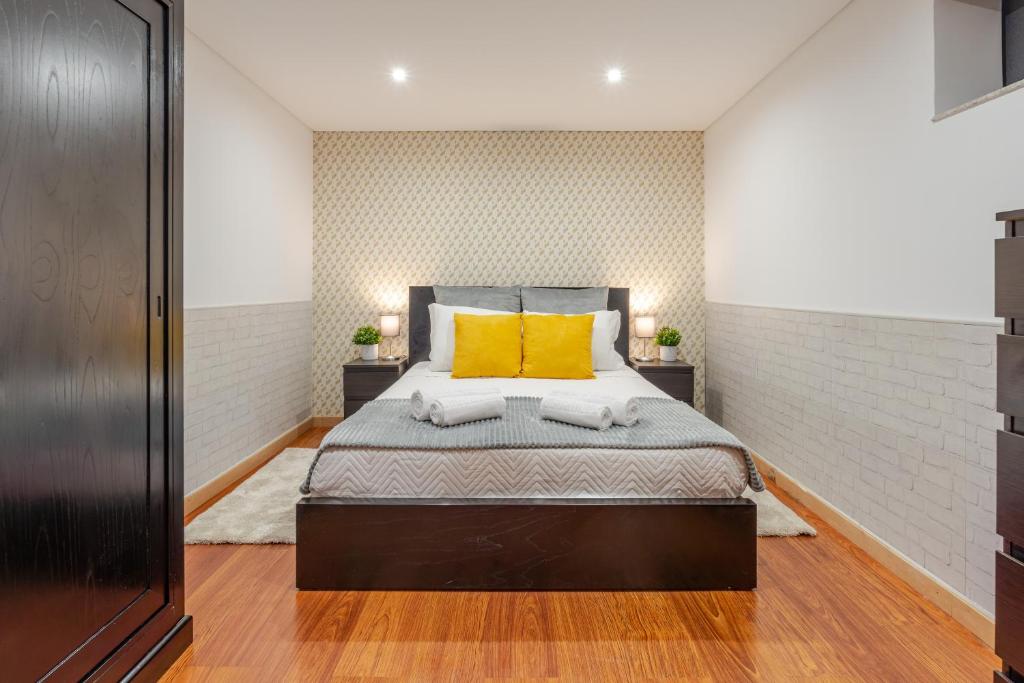 Un dormitorio con una cama con dos almohadas amarillas. en Gardenia Urban Retreat, en Oporto