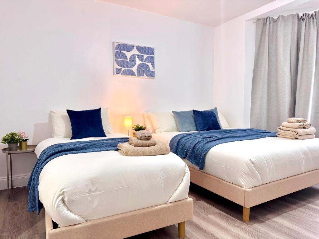 two beds in a bedroom with blue and white at Comfy Studio 30min to Central London in London