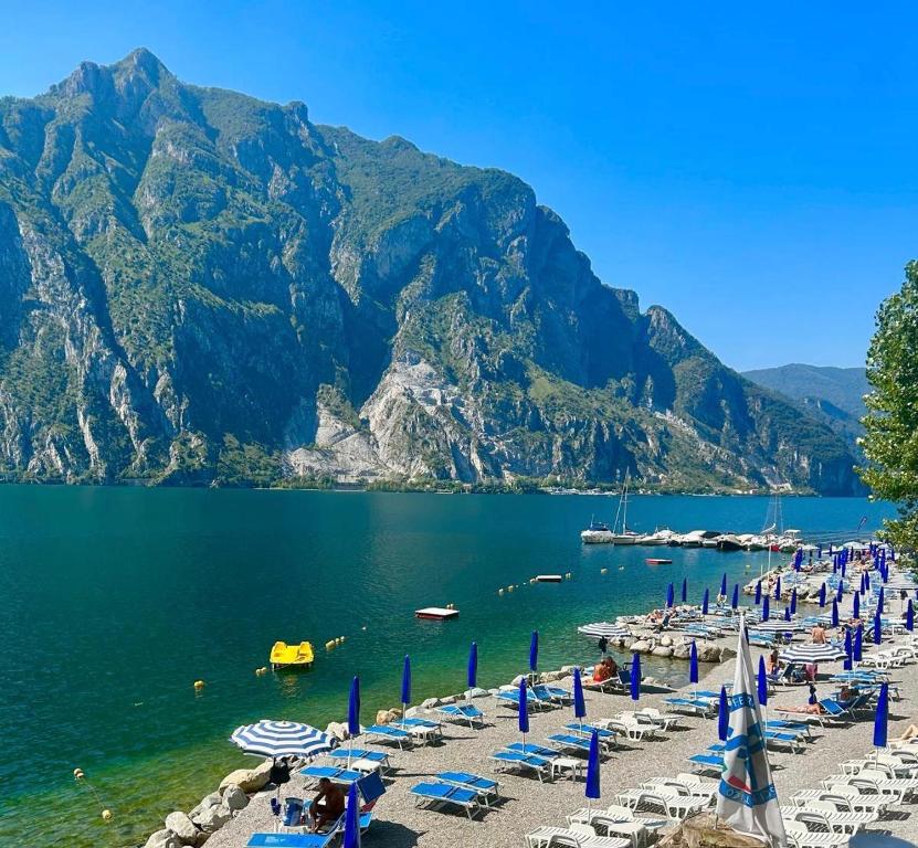 een strand met stoelen en parasols en het water bij Perfect Point Como in Lecco
