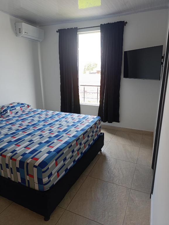 a bedroom with a bed and a large window at Apartaestudio en Tulua Valle in Tuluá