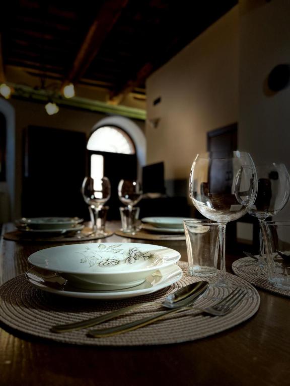 a table with plates and wine glasses on it at casa centro storico in Montefiascone