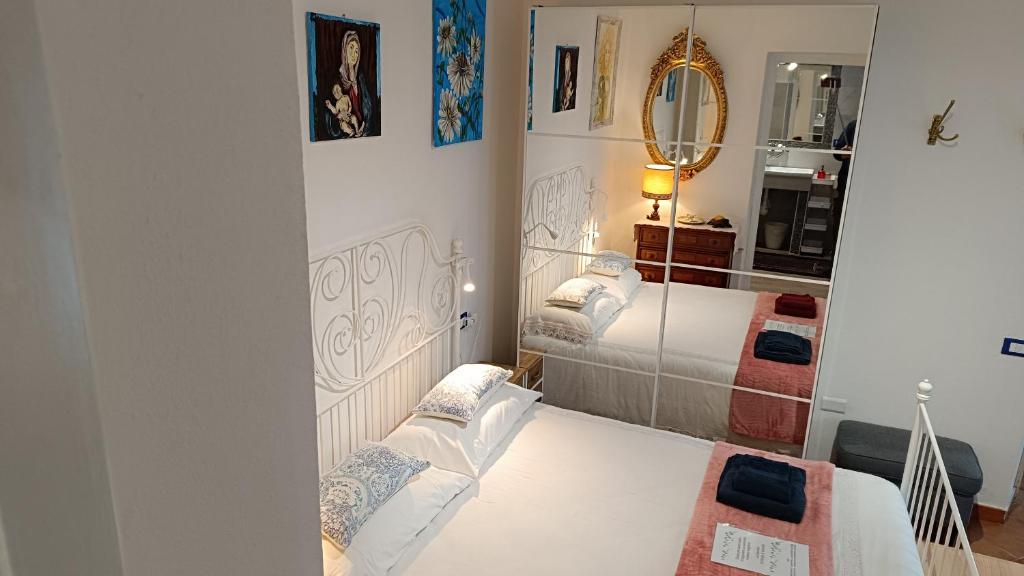 Habitación pequeña con 2 camas y espejo. en Tipica villetta ligure indipendente arredata con gusto e comfort 1 camera da letto parcheggio interno zona Lerici Monti San Lorenzo, en Lerici