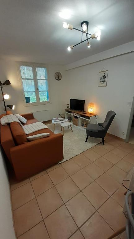 "L'Ostal Daouan" Grand appartement 8 personnes proche La Mongie et Payolle في كامبان: غرفة معيشة مع أريكة وكرسي