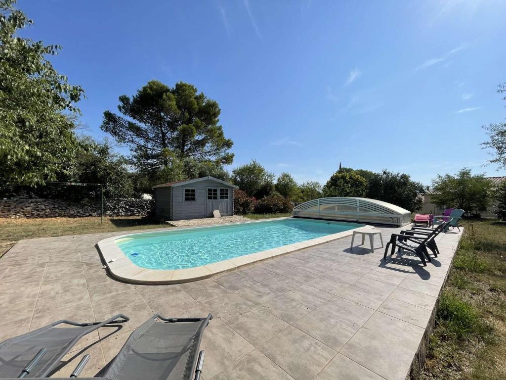 - une piscine entourée d'un groupe de chaises dans l'établissement Villa à Orgnac-l'Aven avec piscine chauffée, 6 pers, jardin clôturé, animaux admis - FR-1-382-127, à Orgnac-lʼAven