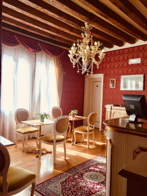 a dining room with a table and chairs and a chandelier at Locanda Correr in Venice