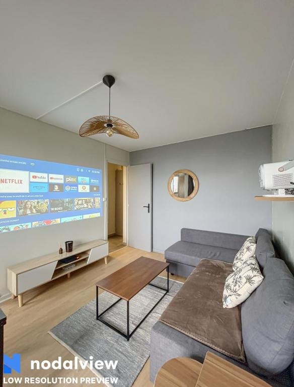 un salon avec un canapé et une table dans l'établissement Cozy renovated apartment with cinema atmosphere and view, à La Mulatière