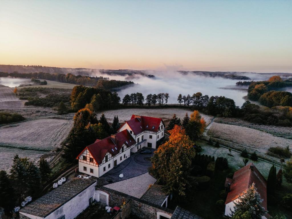 an aerial view of a house in a field with fog at Agroturystyka Kaczor nad jeziorem in Męcidół