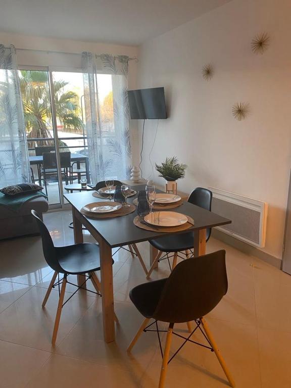 une table à manger et des chaises dans un salon dans l'établissement Appartement tout confort climatisé, à Gruissan