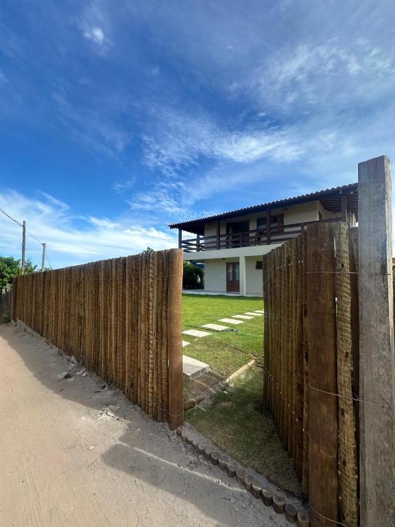 a wooden fence in front of a house at Hospedaria Vale Maion in Caraíva