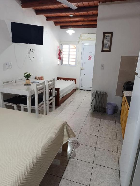 a living room with a table and a bed and a tv at Los Colibríes in San José
