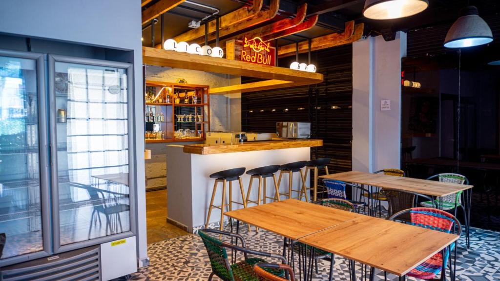 a bar with wooden tables and chairs in a restaurant at Urban Oasis Med in Medellín