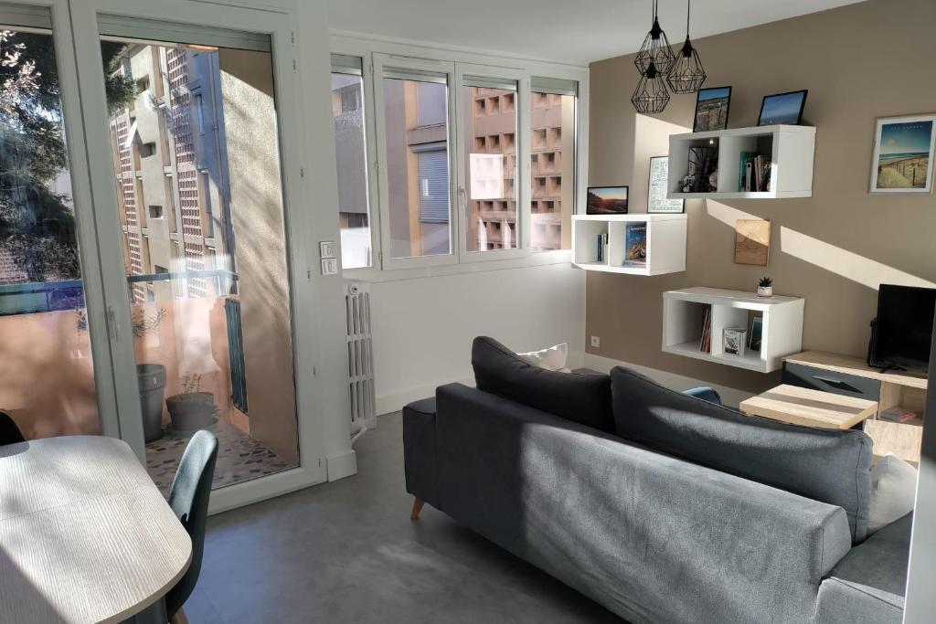 un salon avec un canapé et une fenêtre dans l'établissement Apt of 69 m2 near the city center Montpellier, à Montpellier