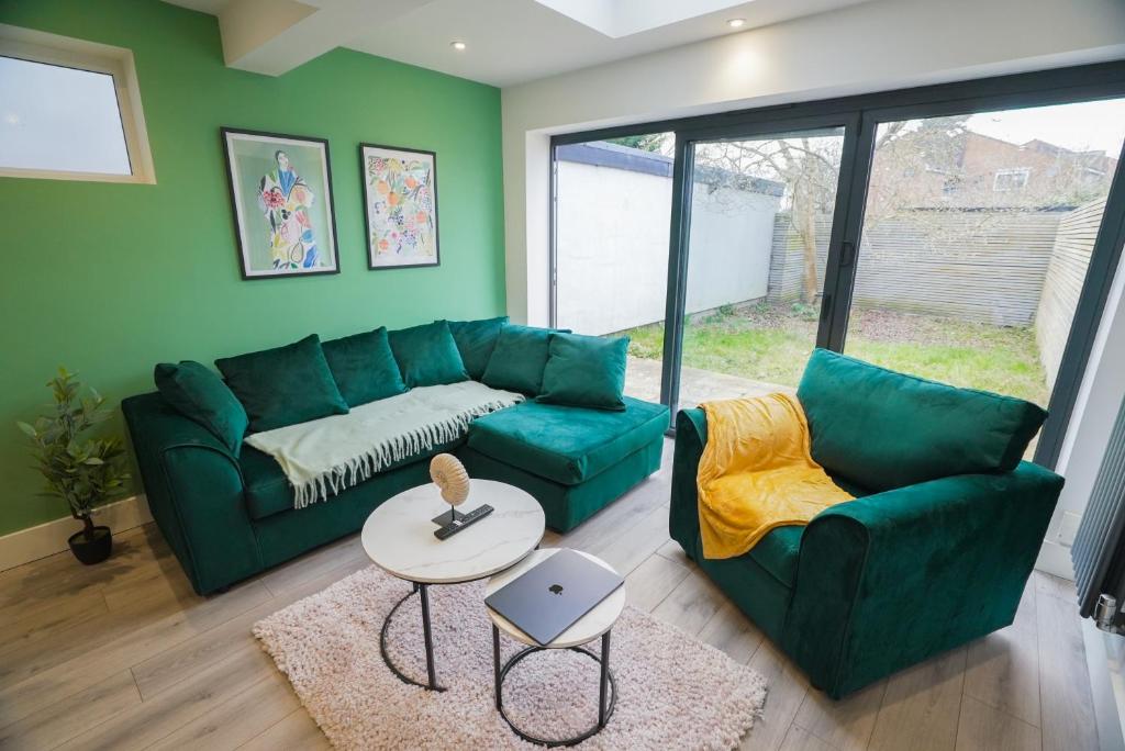 a living room with a green couch and a table at Spacious 5 Bed 3 Bath Gatwick House in Crawley