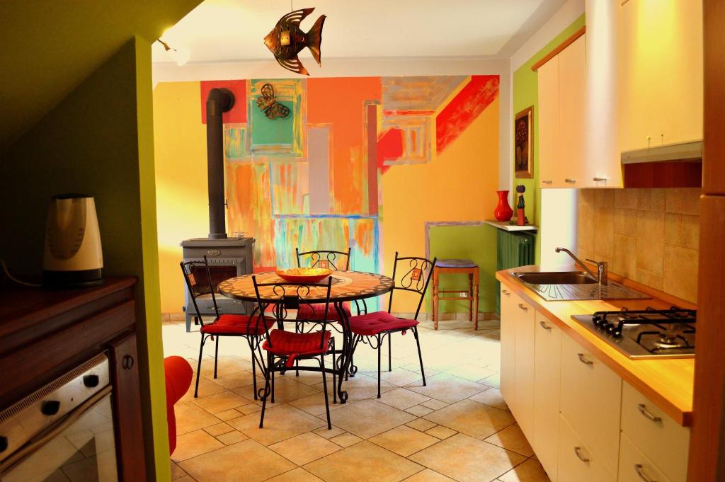 a kitchen with a table and chairs and a stove at Agriturismo Casa de Colores in Moretta