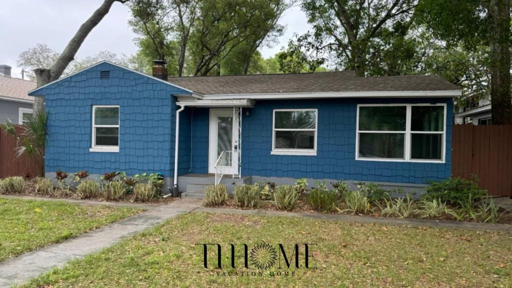 een blauw huis met planten in de voortuin bij The Little Blue House Kenwood Ping Pong Hockey Family in St Petersburg