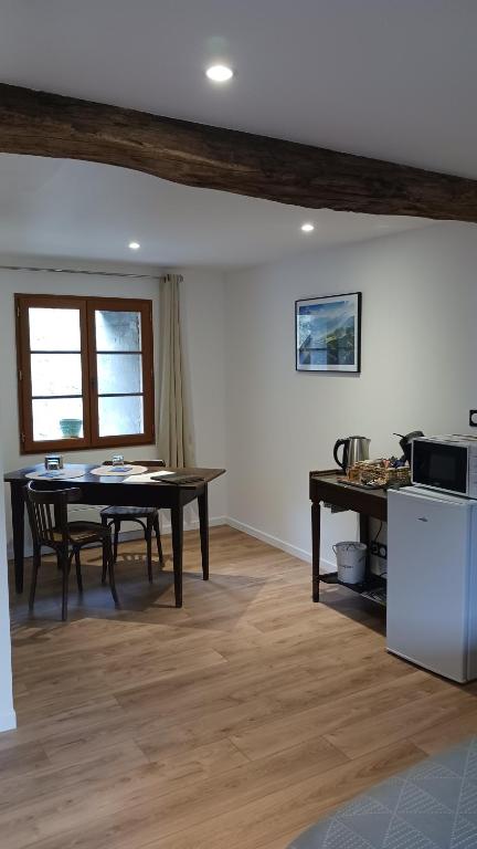 a dining room with a table and a kitchen at Les Nuits de Vieillespeze in Saint-Projet-de-Salers