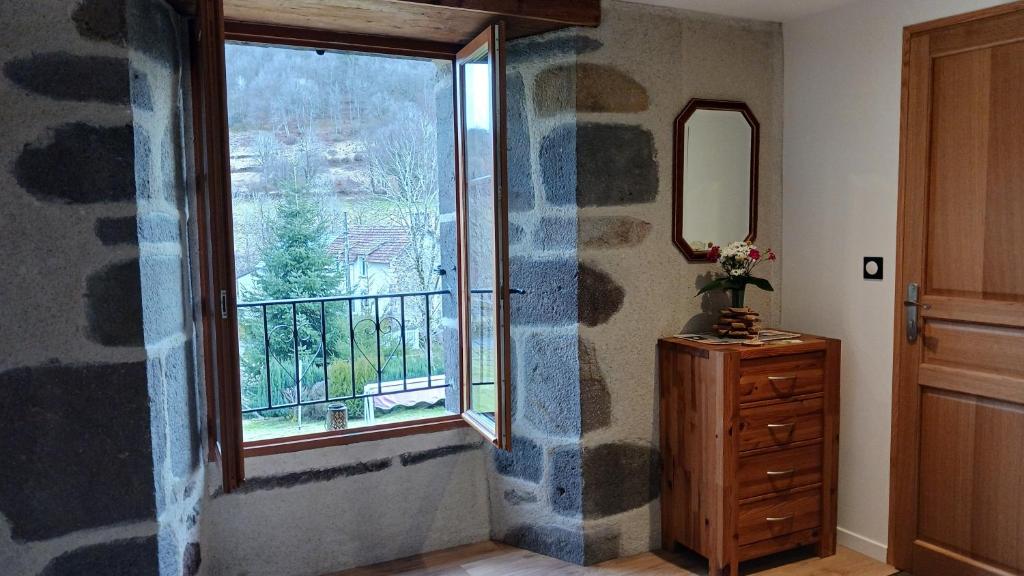 a room with a window and a dresser and a mirror at Les Nuits de Vieillespeze in Saint-Projet-de-Salers