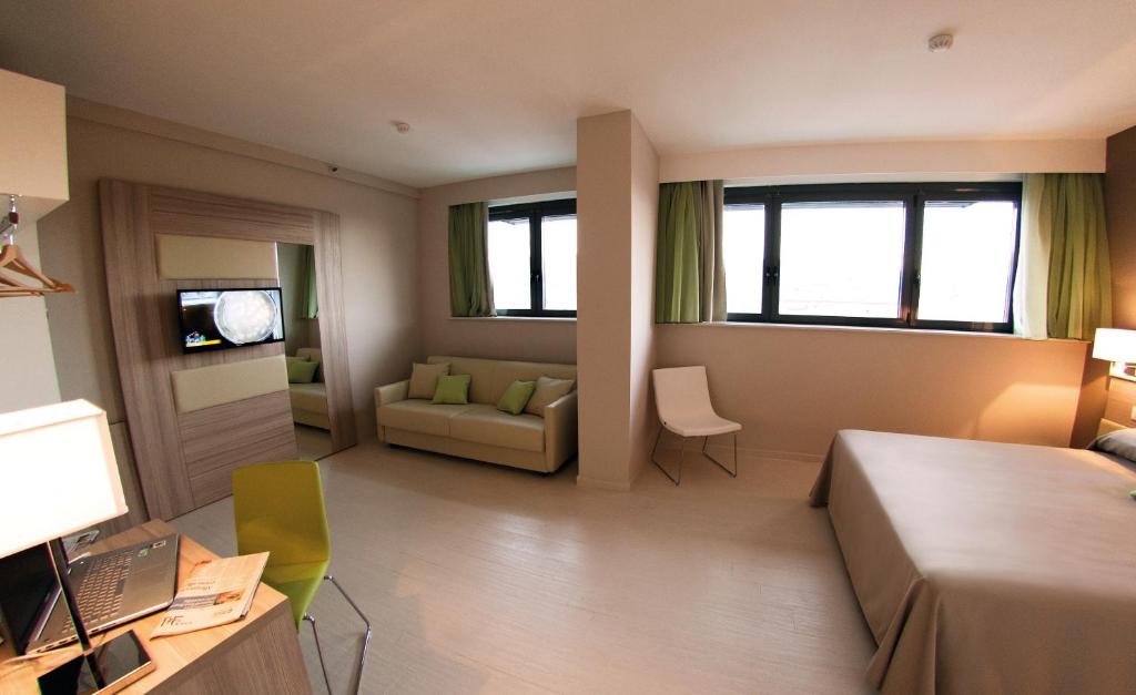 a large room with a bed and a couch at Hotel Cristina in Naples
