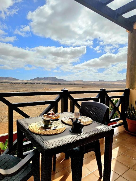 a table with two plates of food on a balcony with a view at Casalegre in El Cotillo