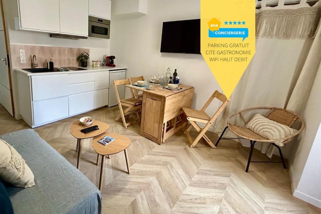 Il comprend un petit salon avec une table et une cuisine. dans l'établissement La reine du faubourg, à Dijon