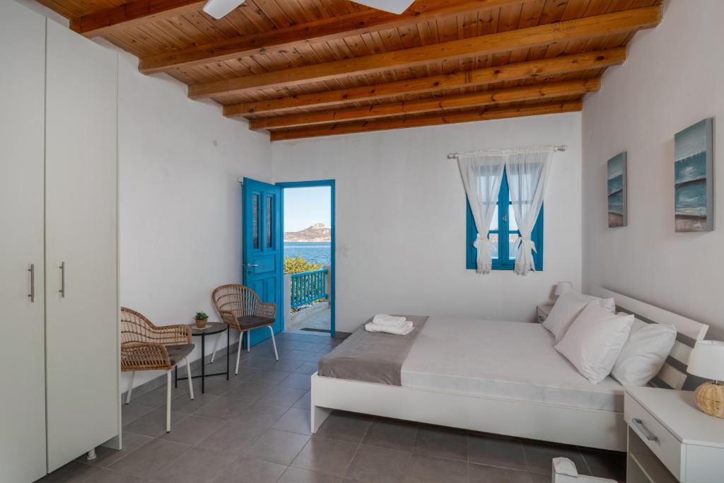 a bedroom with a bed and a table and chairs at Milos Sea House in Empourios