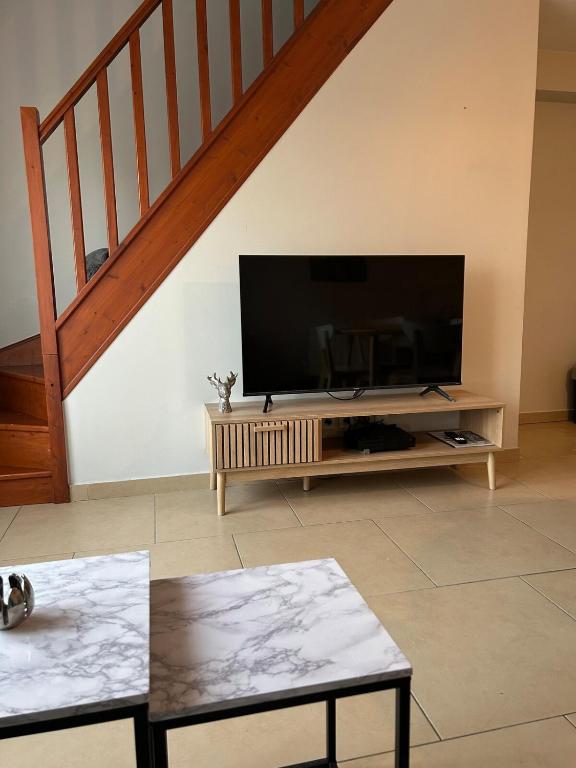 un salon avec une télévision à écran plat sur un centre de divertissement dans l'établissement Appartement cosy idéalement situé, à Chelles