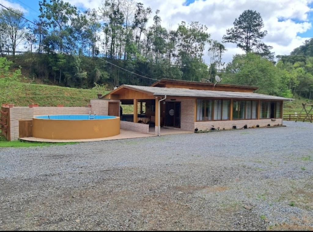 a house with a swimming pool in front of it at Sitio e Pousada Som das Águas in Barracão