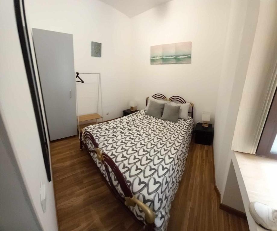 ein Schlafzimmer mit einem Bett in einem weißen Raum in der Unterkunft A casinha in Nazaré