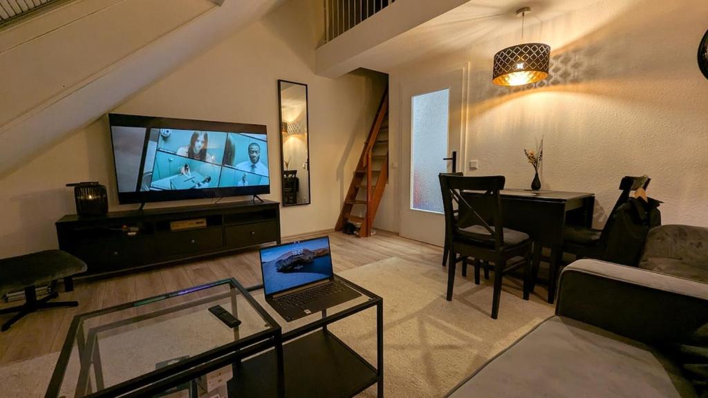 a living room with a television and a table with a laptop at FeWo EssensStube - Gemütlich - Geräumig - Gut in Essen