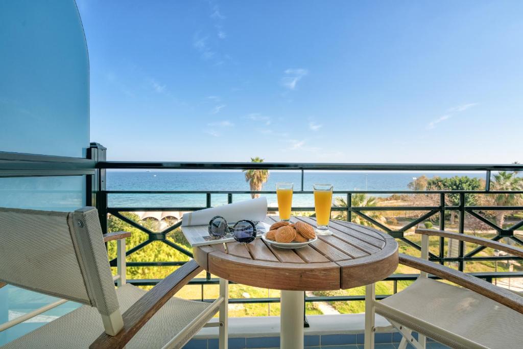 einen Tisch mit einem Teller Essen auf dem Balkon in der Unterkunft Plaza Hotel in Zakynthos