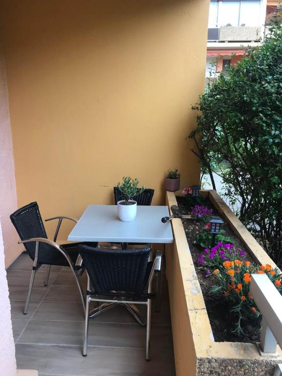 d'une table et de chaises sur un balcon fleuri dans l'établissement La Faviere T2 4pers RDC avec Terrasse, à Bormes-les-Mimosas