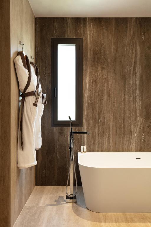 a bathroom with a white tub and a window at Villa Cosy, hotel & spa in Saint-Tropez
