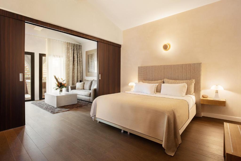 a bedroom with a large bed and a living room at Villa Cosy, hotel & spa in Saint-Tropez