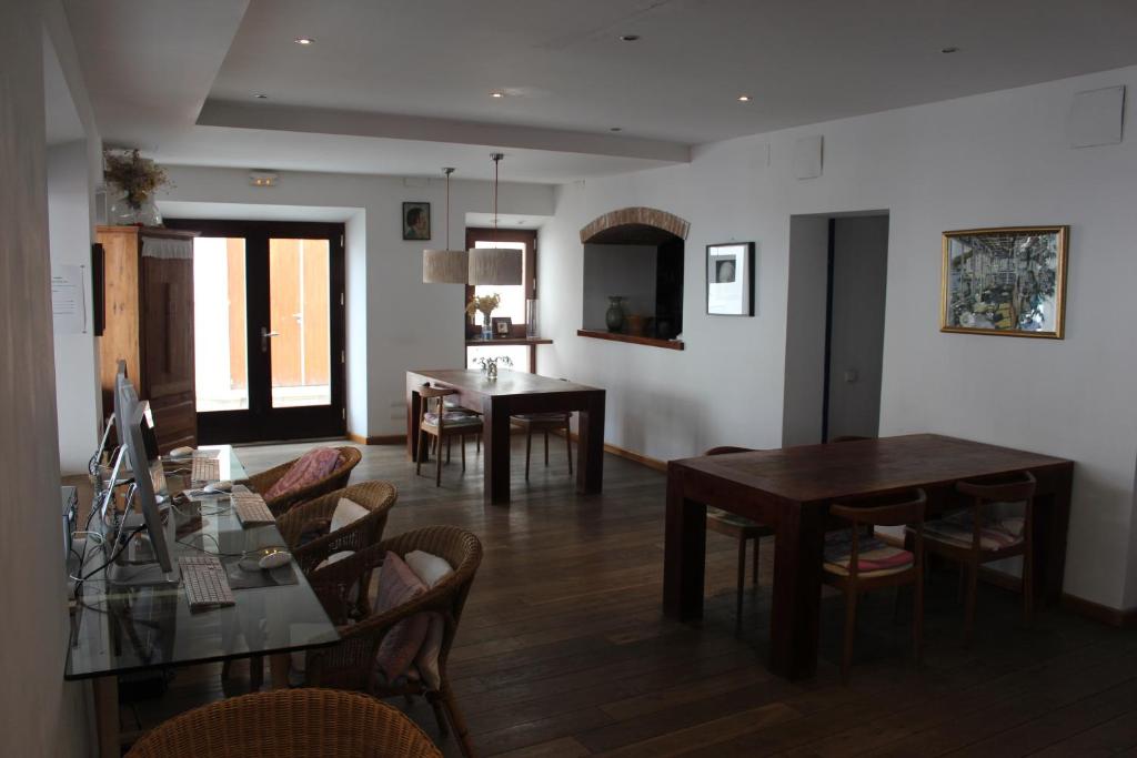 a dining room and living room with tables and chairs at Hostal Cristina in Cadaqués