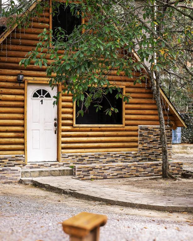 a log cabin with a white door and a window at Cabañas Rincon del Ángel 1 in Ciénaga