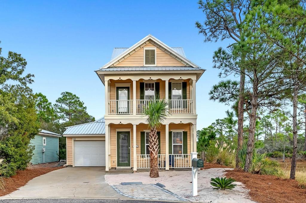 una casa con una palmera delante en Beach Haven, en Gulf Highlands