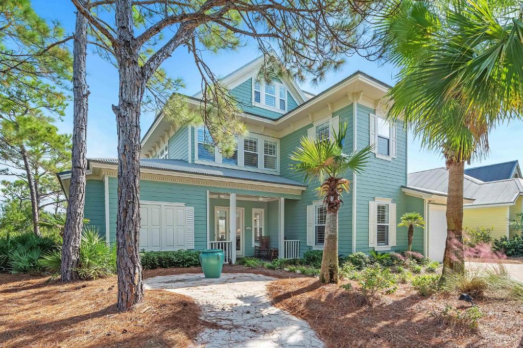 a blue house with palm trees in front of it at Blue Bayou in Gulf Highlands