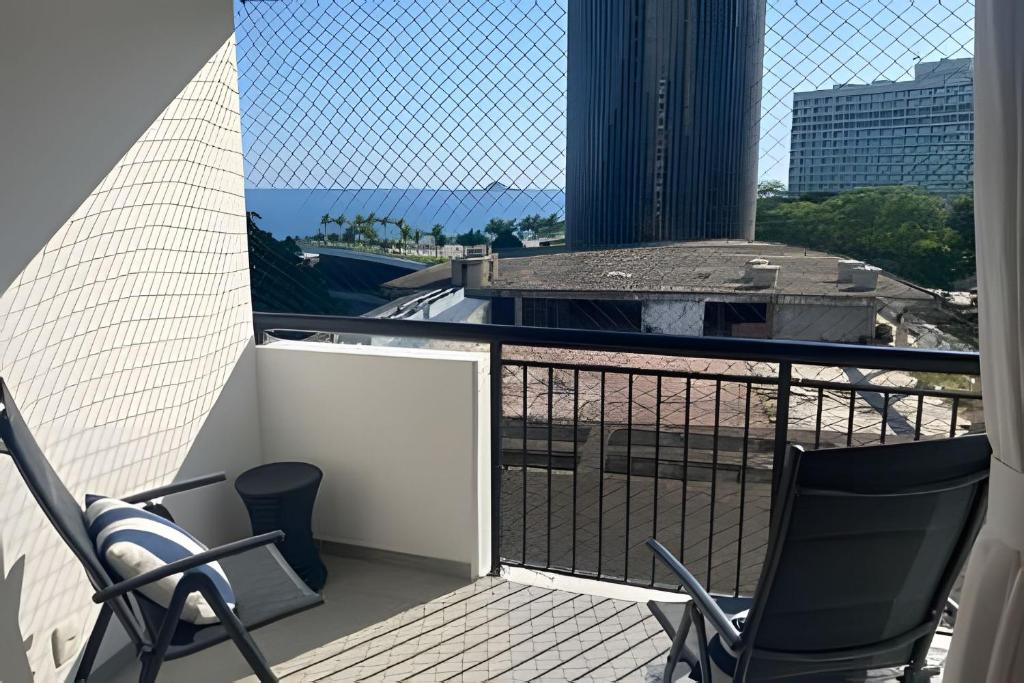 a balcony with chairs and a view of the city at 2 quartos São Conrado ao lado Hotel Nacional in Rio de Janeiro