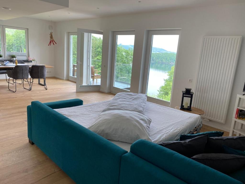 a bedroom with a blue couch in a room with windows at #2 Ommi Kese Sansibar Apartment Panorama Balkon in Olpe