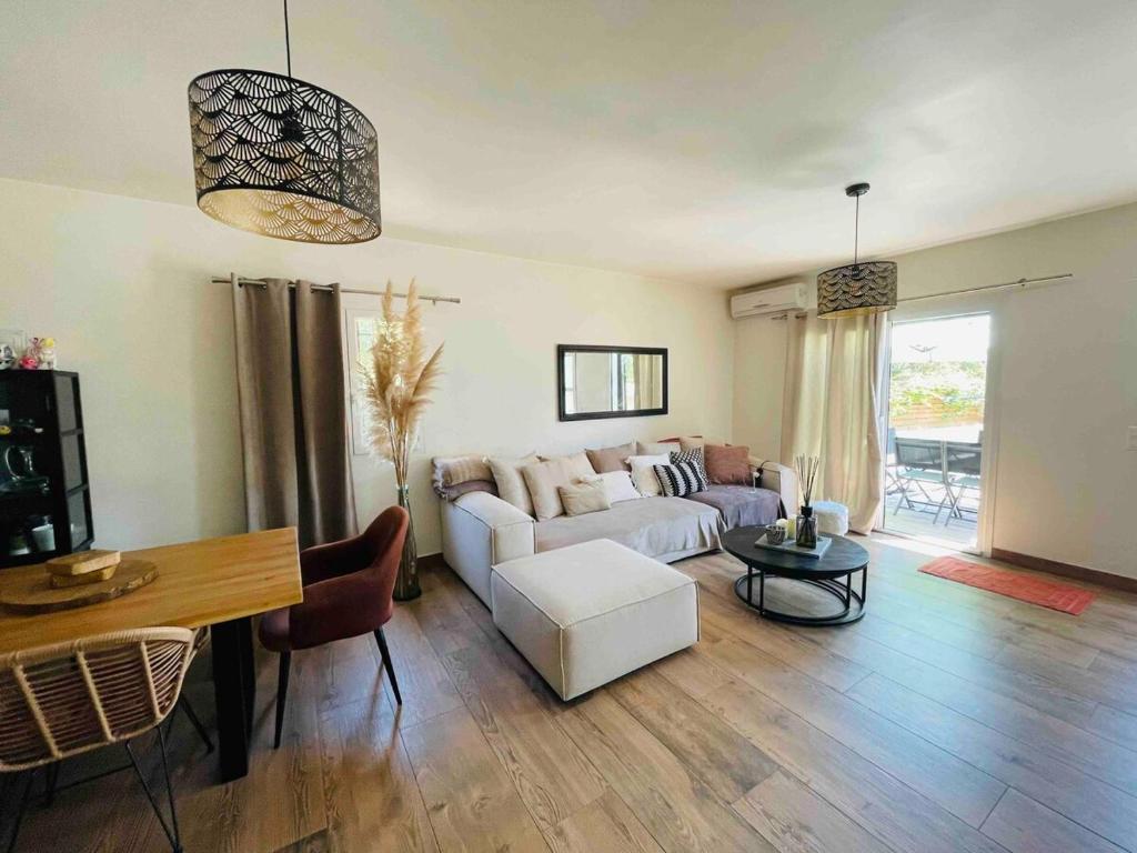 un salon avec un canapé blanc et une table dans l'établissement Villa Zanzibar Porto-vecchio, à Porto-Vecchio