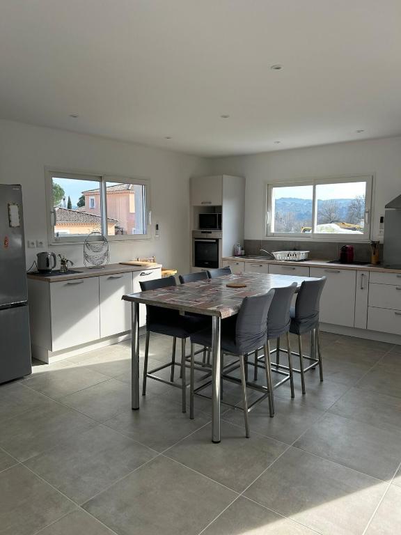 une cuisine avec une table et des chaises dans l'établissement Villa daudet, à Vallon-Pont-dʼArc