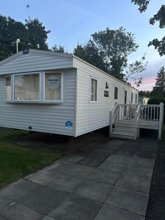 a small white trailer with a porch on a driveway at Haggerston Castle 6 Berth Caravan - Riverside 37 in Cheswick