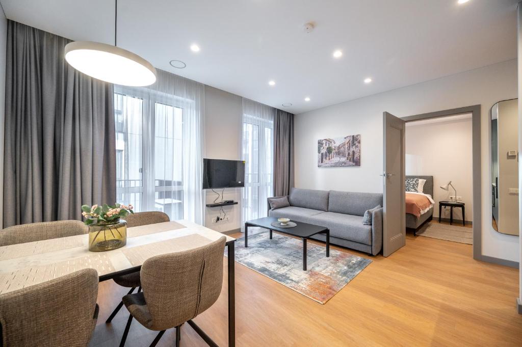 una sala de estar con un sofá y una mesa en Brand New Downtown Apartments by Reside Baltic, en Vilna